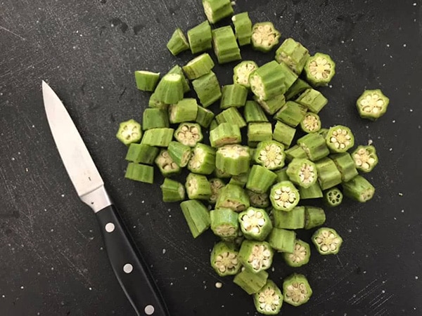 Top view of cut bhindi with a small knife next to it