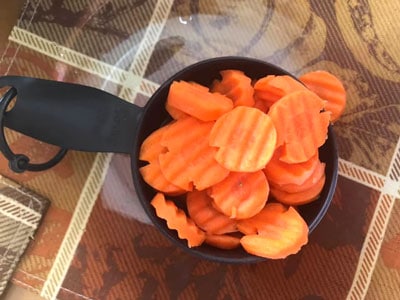carrots in a measuring cup inside a glass bowl
