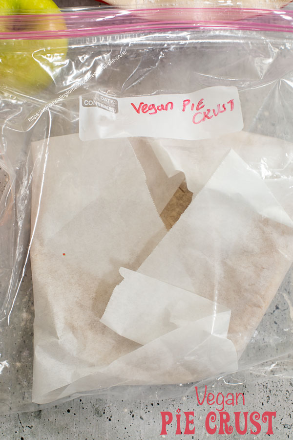 Top view of a pie crust wrapped in parchment paper and placed inside a ziploc bag