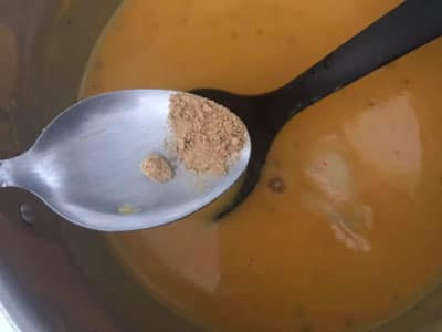 ginger powder being added to soup