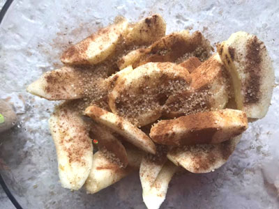 brown sugar added to apple wedges in bowl