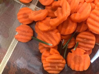 Rosemary leaves put into bowl with crinkle carrots