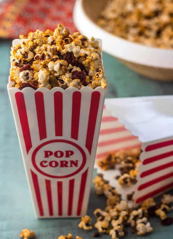 Front view of an old-fashioned popcorn cup filled with sweet tajin popcorn - dried cranberries