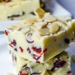 Front view of 2 squares of white chocolate fudge stacked on top of each other - dried cranberries