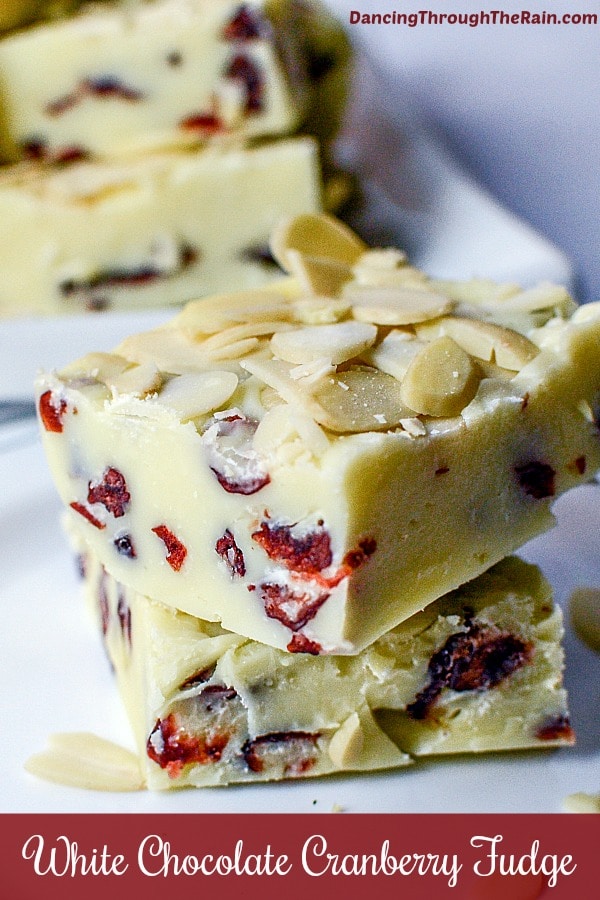 Front view of 2 squares of white chocolate fudge stacked on top of each other - dried cranberries