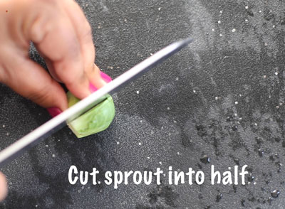 The author using a large kitchen knife to cut the sprout into half