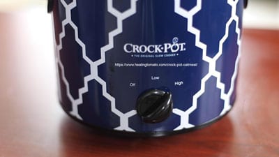 The front of a blue crock-pot with the setting set to high