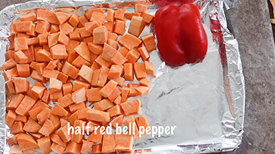 Half of a red bell pepper placed cut side down on the tray