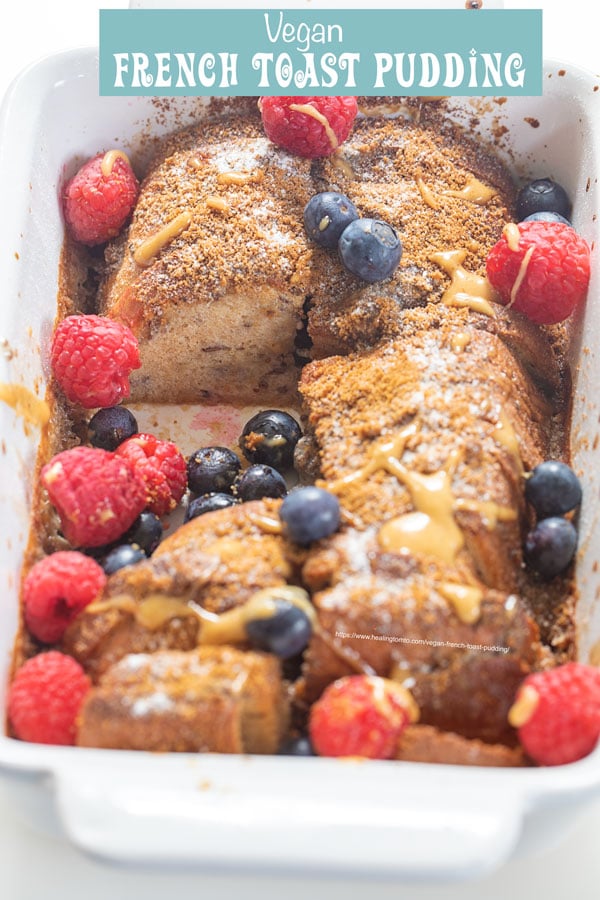 45° angle view of the French Toast Casserole with a portion taken out to show the inside of it. Berries and almond syrup garnish visible too.