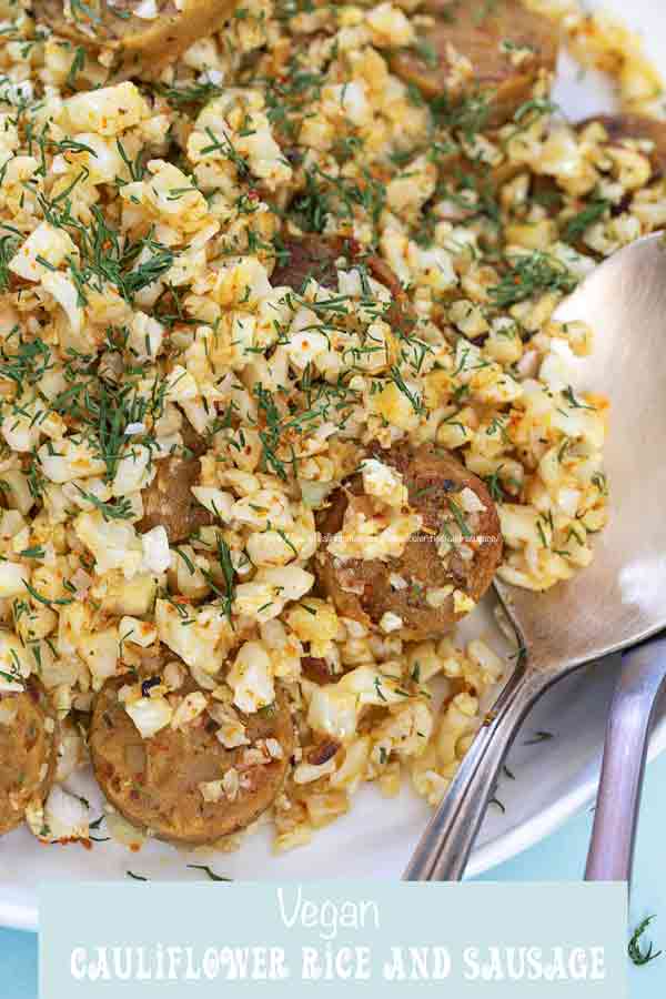 Closeup view of the rice and sausage on a white plate with two spoons on the bottom right