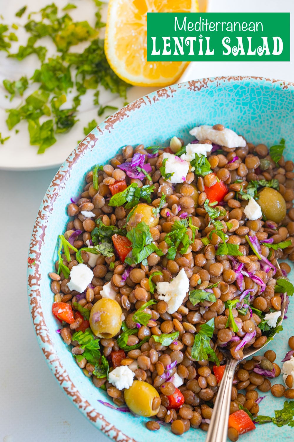 Top view of lentil salad in a light blue bowl with a spoon next to it