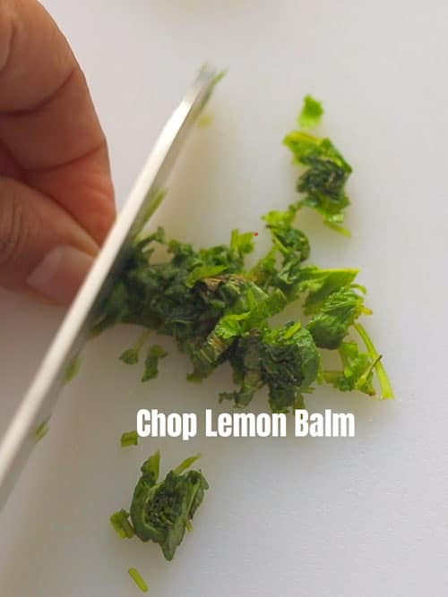 top view of the author chopping lemon balm leaves