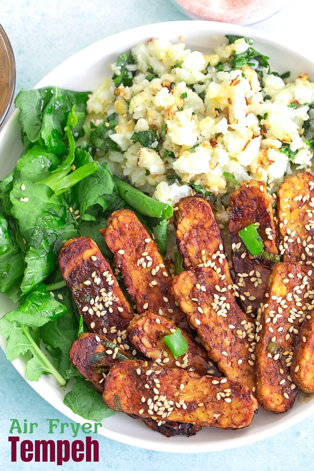 Top closeup view of tempeh in a bowl with sesame seeds for garnish