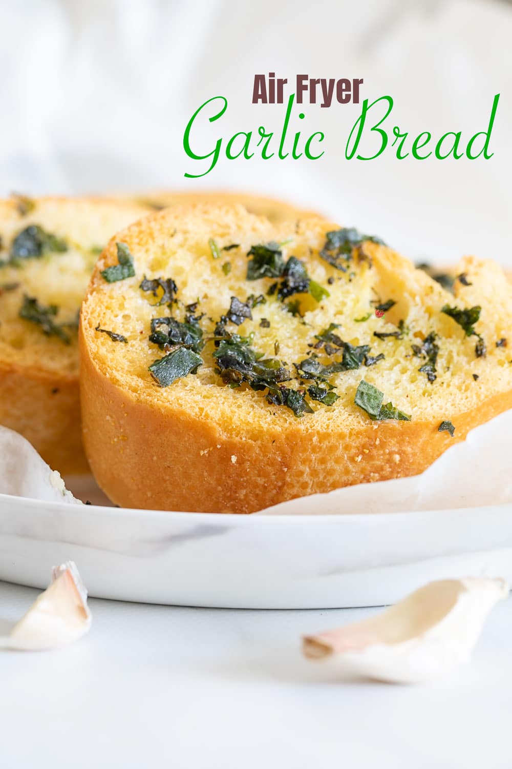 Side view of a slice of garlic bread on white plate