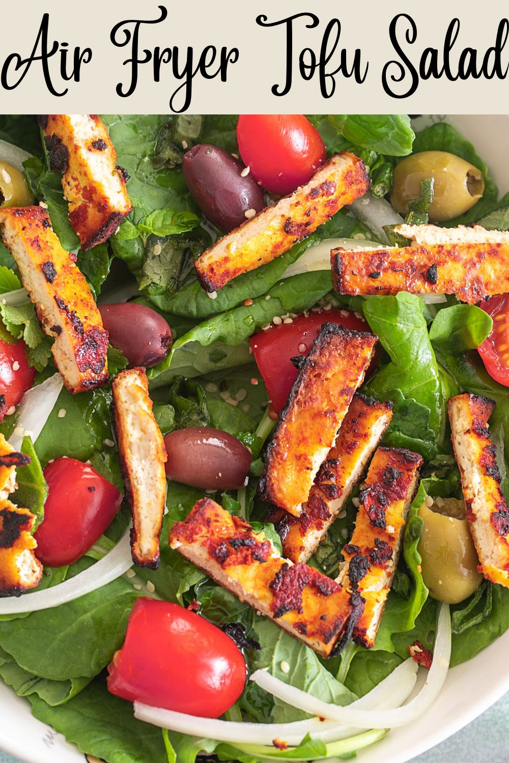 Top, closeup view of long roasted tofu over a bed of green salad. Easy healthy recipes