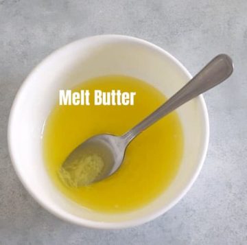 melted butter in a white bowl with a spoon in it.