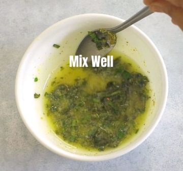 All the ingredients in the white bowl being mixed with a spoon
