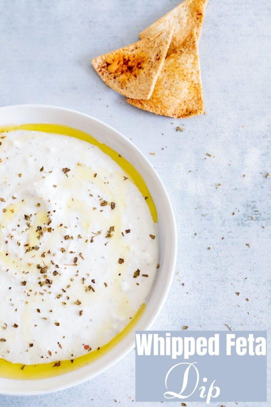 Closeup view of a white bowl filled with the whipped feta bowl with oil and seasoning as garnish.