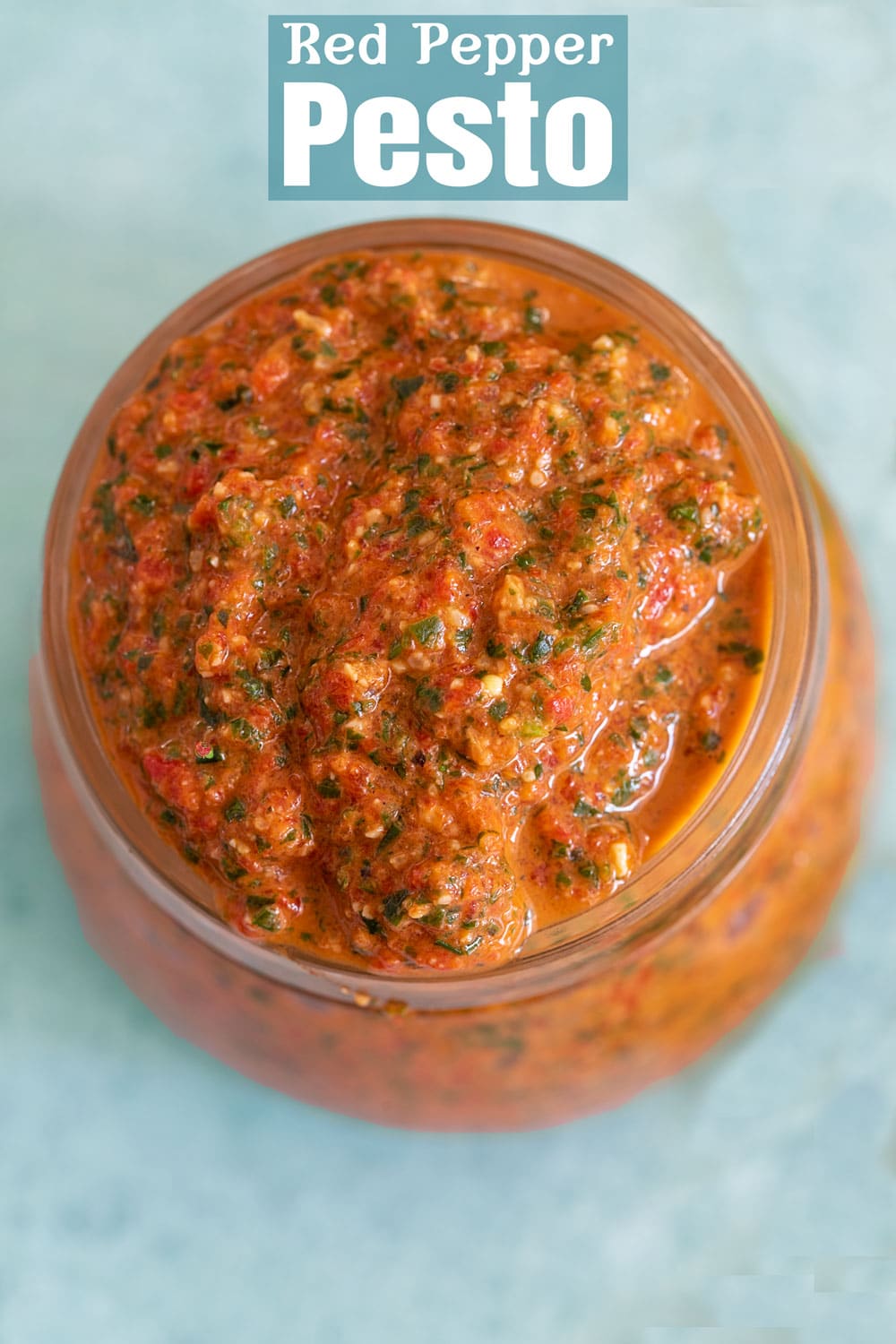 Top and closeup view of bell pepper pesto in a glass jar
