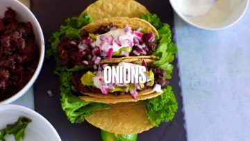 Chopped red onions are the last topping added on top of the tacos