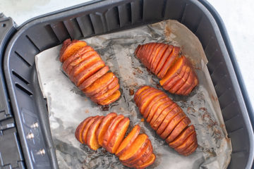 top view of 4 air fryed sweet potatoes with hasselback cut