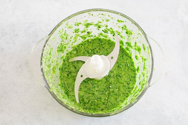 Top view of a blended scallion pesto sauce in the food processor