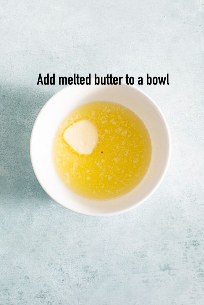 top view of a white bowl with a partially melted butter stick