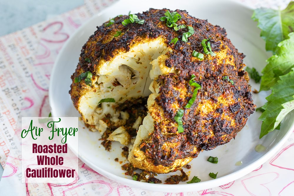 Top and angle view of a roasted cauliflower with a crossection cut off to expose the inside.