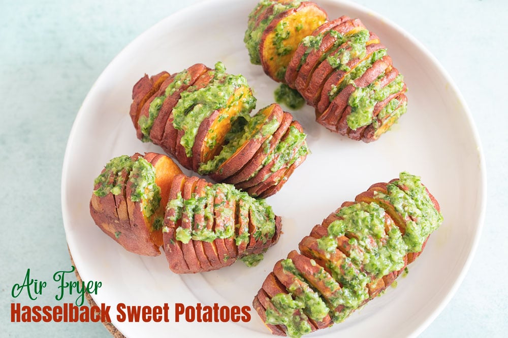 Top view of 4 baby hasselback sweet potatoes with a scallion pesto topping on a white plate