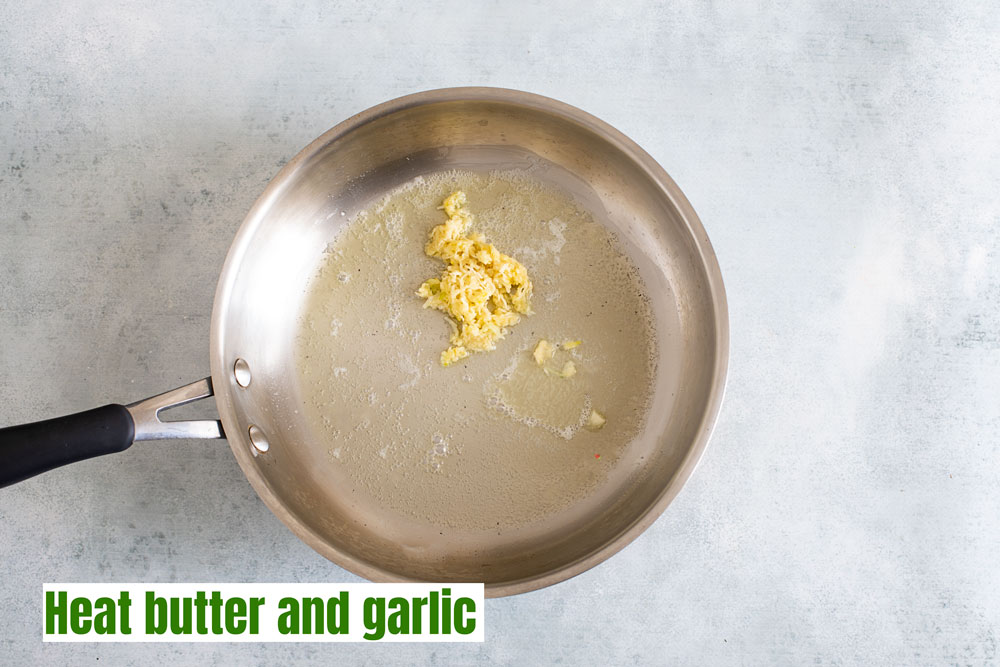 top view of the melted butter and minced garlic in a stainless steel pan