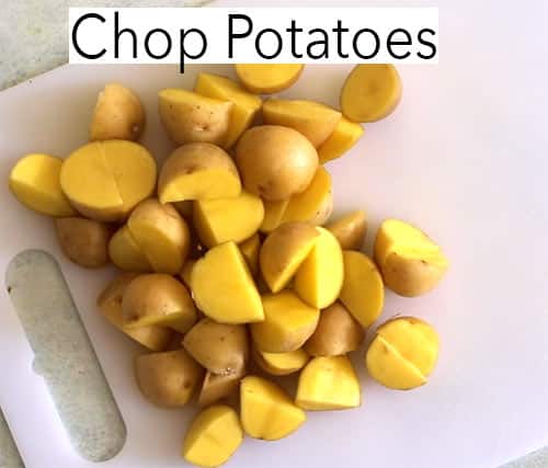 Top view of chopped honey gold potatoes on a white chopping board