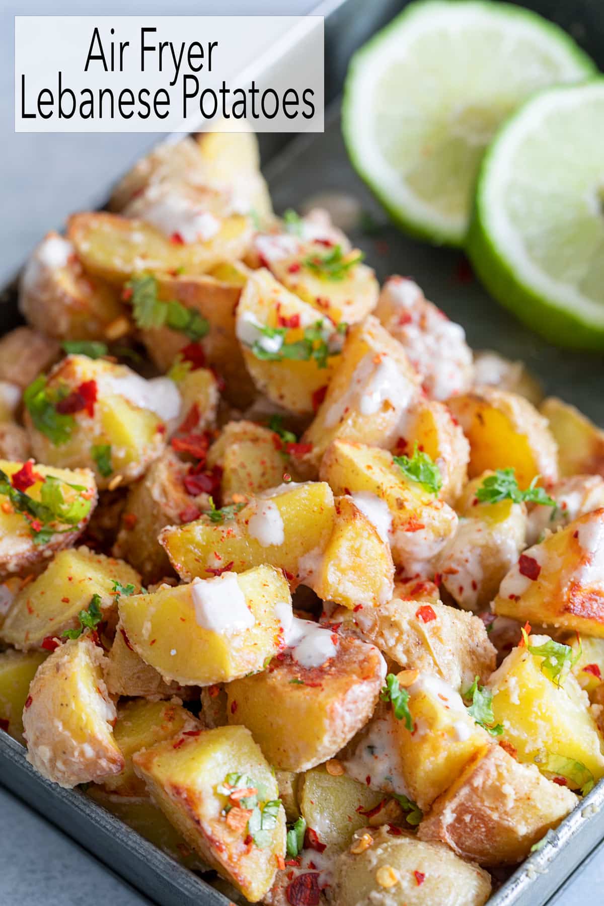 Closeup view of potato cubes with tahini, cilantro and red pepper flake garnishes.