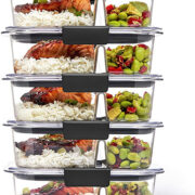 Five 2-compartment glass containers stacked on top of each other.  There is generic food around it.  