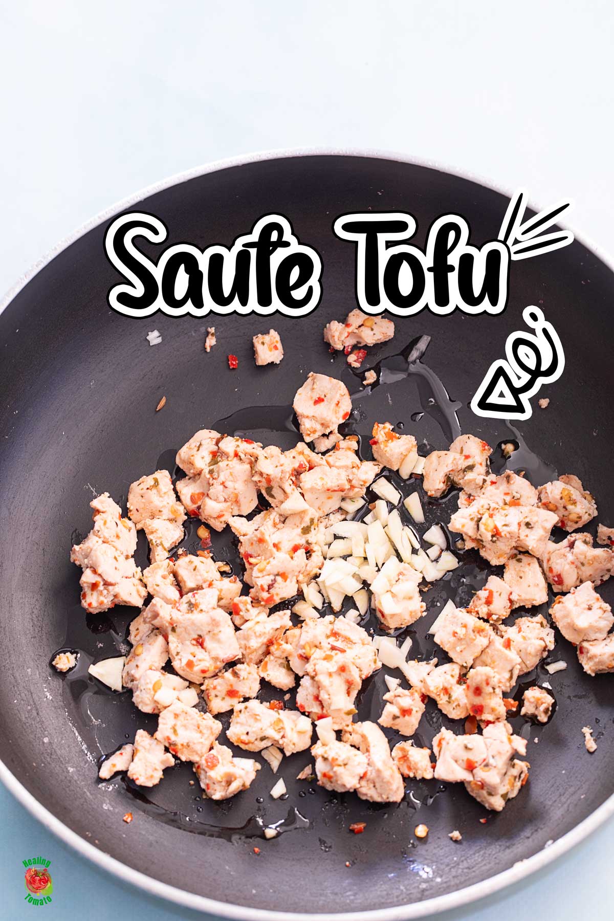 Top view of harissa marinated tofu in a wok with garlic. Title of "saute tofu"
