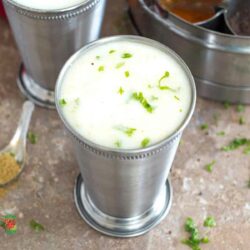 Angle view of a mint julep glass filled with white salted lassi and garnished with cilantro.