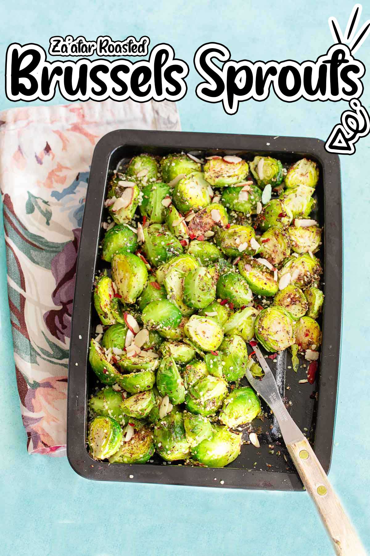Top view of a black sheete pan with the sprouts in it and placed over a blue background