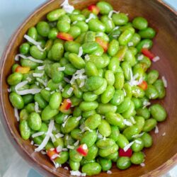 Top and closeup view of unshelled edamame salad with bell pepper and shredded coconut