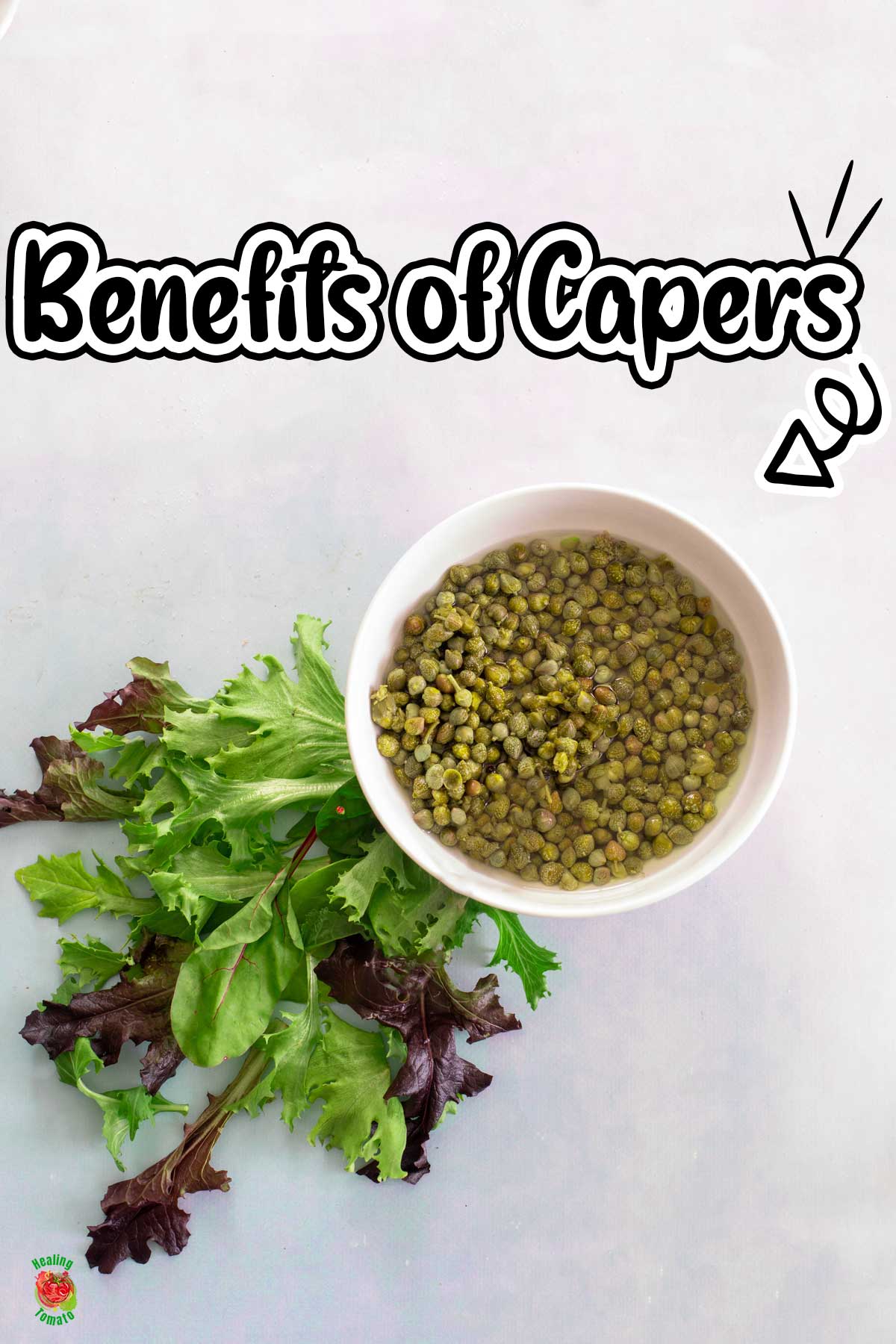 Top view of capers in a white bowl. On the bottom left side, there are a few greens.