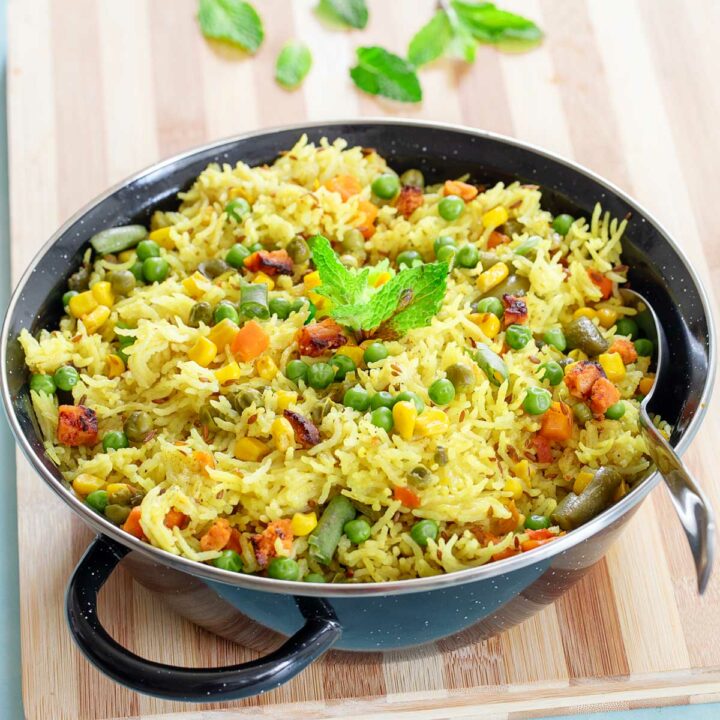 Close up and 45° angle view of a black braiser pan filled with vegan fried rice.