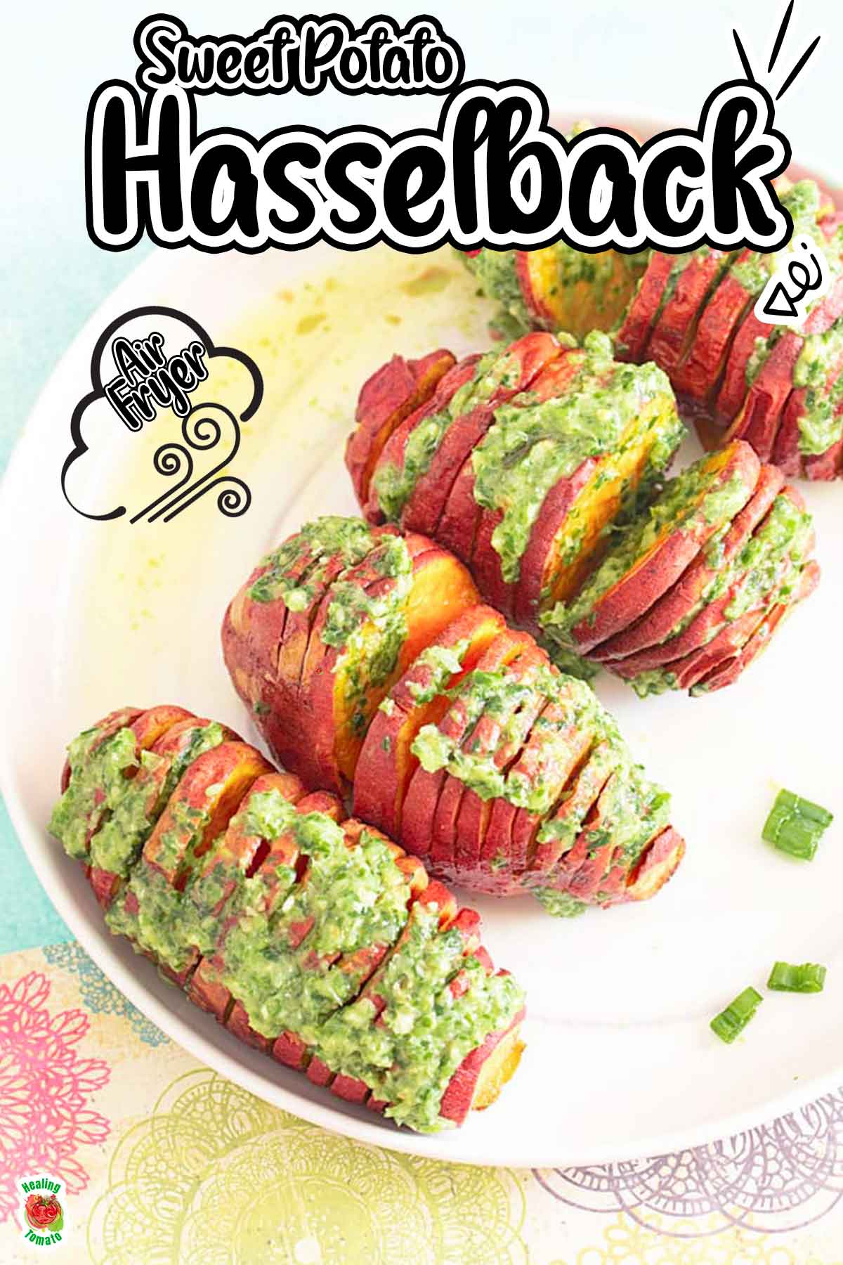 Top view of 4 small sweet potatoes hasselback on a white plate topped with pesto
