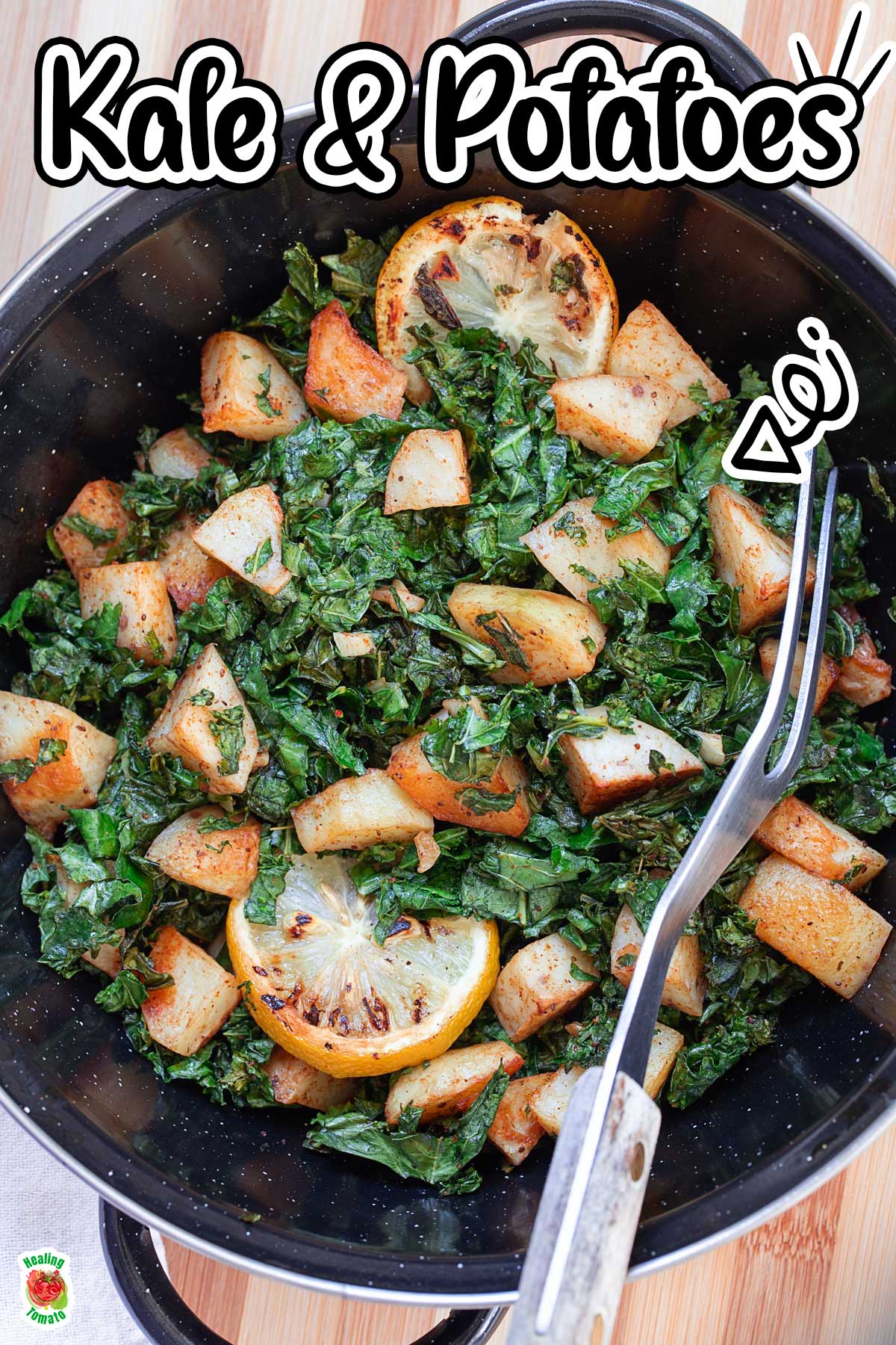 Top view of a black wok filled with sauteed kale and potatoes. Wok is on a brown chopping board