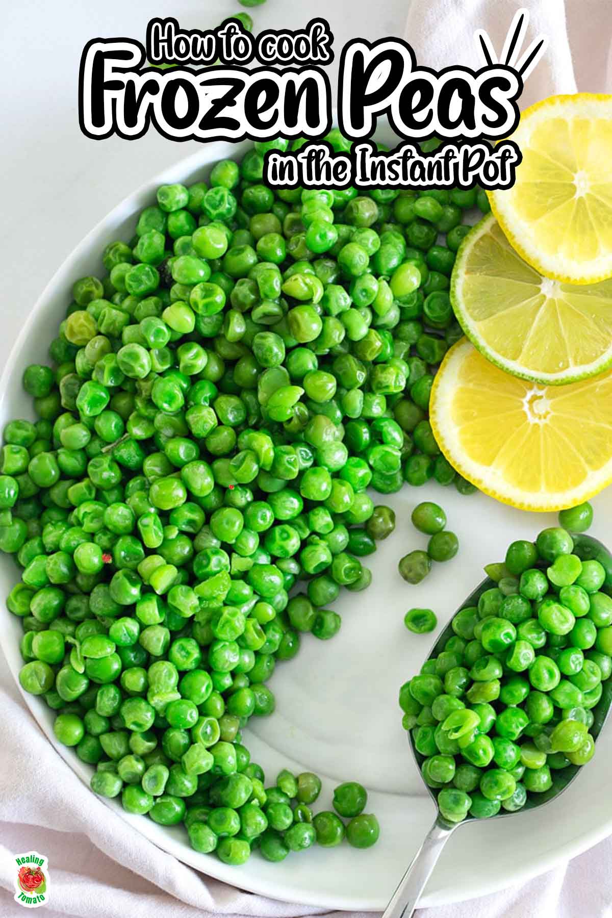 Closeup view of a white plate filled with cooked green peas and a serving spoon with lemon rounds on top of the plate.