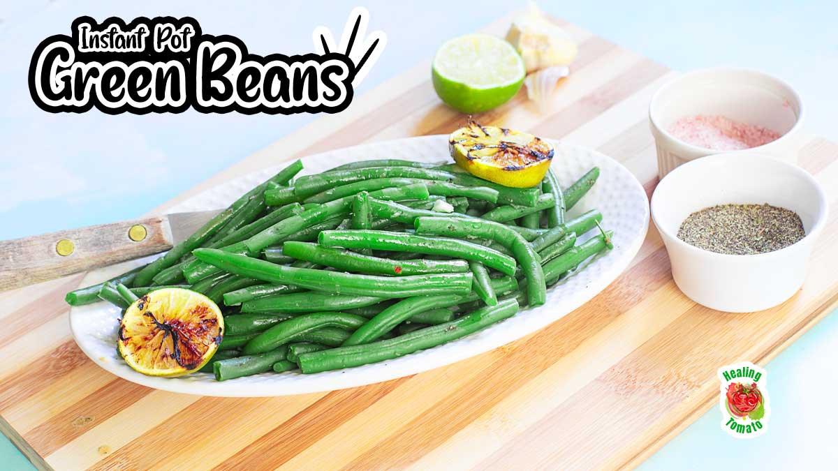 Angle view of green beans in a white serving dish placed on a brown cutting board