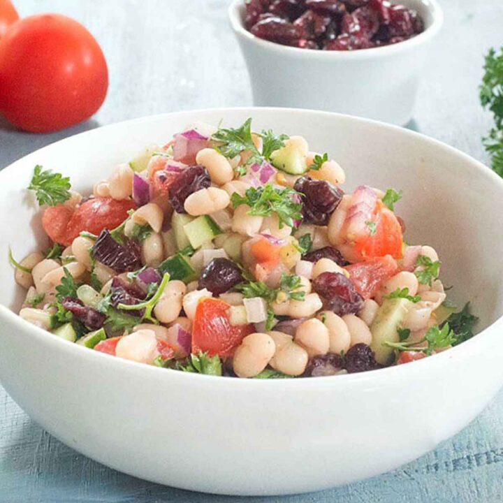 Front view and closeup of the navy bean salad in a white bowl.