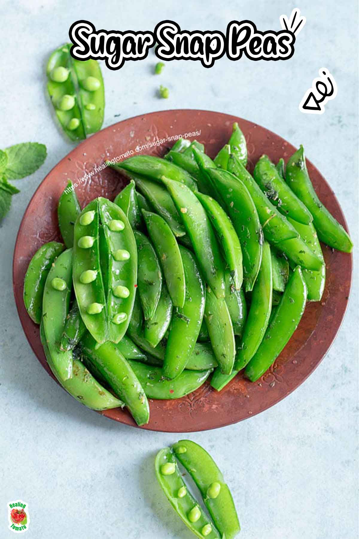 Top view of sugar snap peas on a brown copper plate. One pea pod is left open next to the copper plate